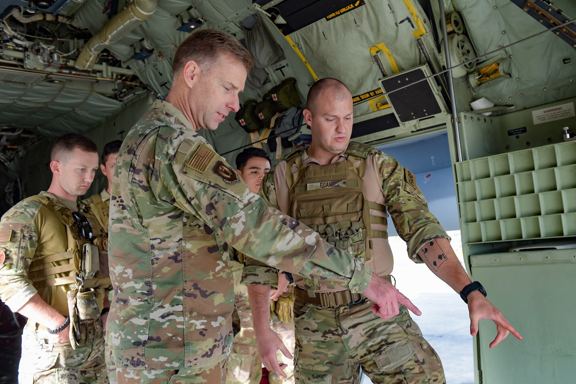 A photo of Airmen speaking and pointing.