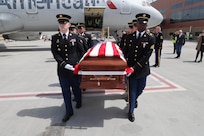 Honor Guard performs an Honorable Carry of a flag draped coffin.