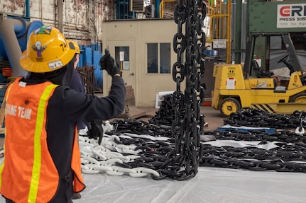 Shop 72 Riggers use cranes to lift anchor chains currently being worked on at Norfolk Naval Shipyard.