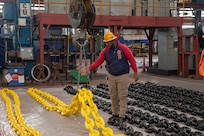 Shop 72 Riggers use cranes to lift anchor chains currently being worked on at Norfolk Naval Shipyard.