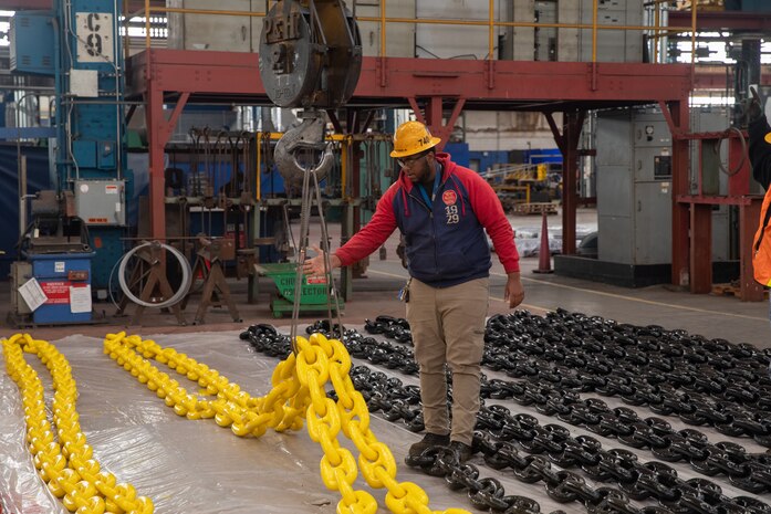 Shop 72 Riggers use cranes to lift anchor chains currently being worked on at Norfolk Naval Shipyard.