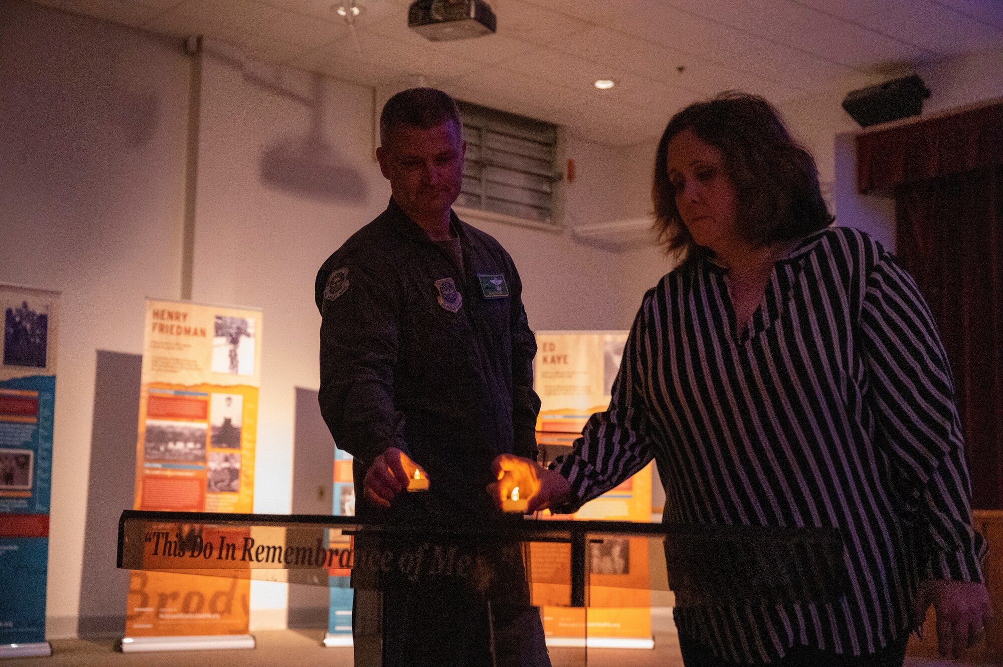 U.S. Air Force Col. Brian Collins, left, vice commander, and Sarah Amato, chief of public affairs, both with the 62nd Airlift Wing, participate in the candle-lighting portion of the Holocaust Remembrance Day ceremony at Joint Base Lewis-McChord, Washington, April 28, 2022. The ceremony gave Airmen the opportunity to learn about the Holocaust and experiences of survivors. (U.S. Air Force photo by Airman 1st Class Charles Casner)