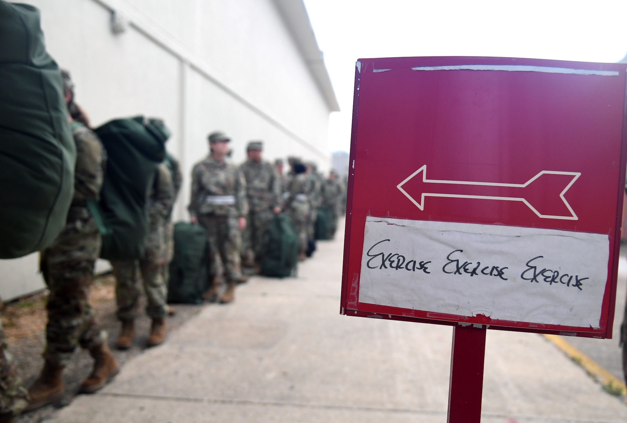 Airmen from the 81st Training Group line up outside of Allee Hall for shelter in-processing during a hurricane exercise at Keesler Air Force Base, Mississippi, April 29, 2022. Keesler personnel participate in exercise scenarios in preparation for hurricane season. (U.S. Air Force photo by Kemberly Groue)
