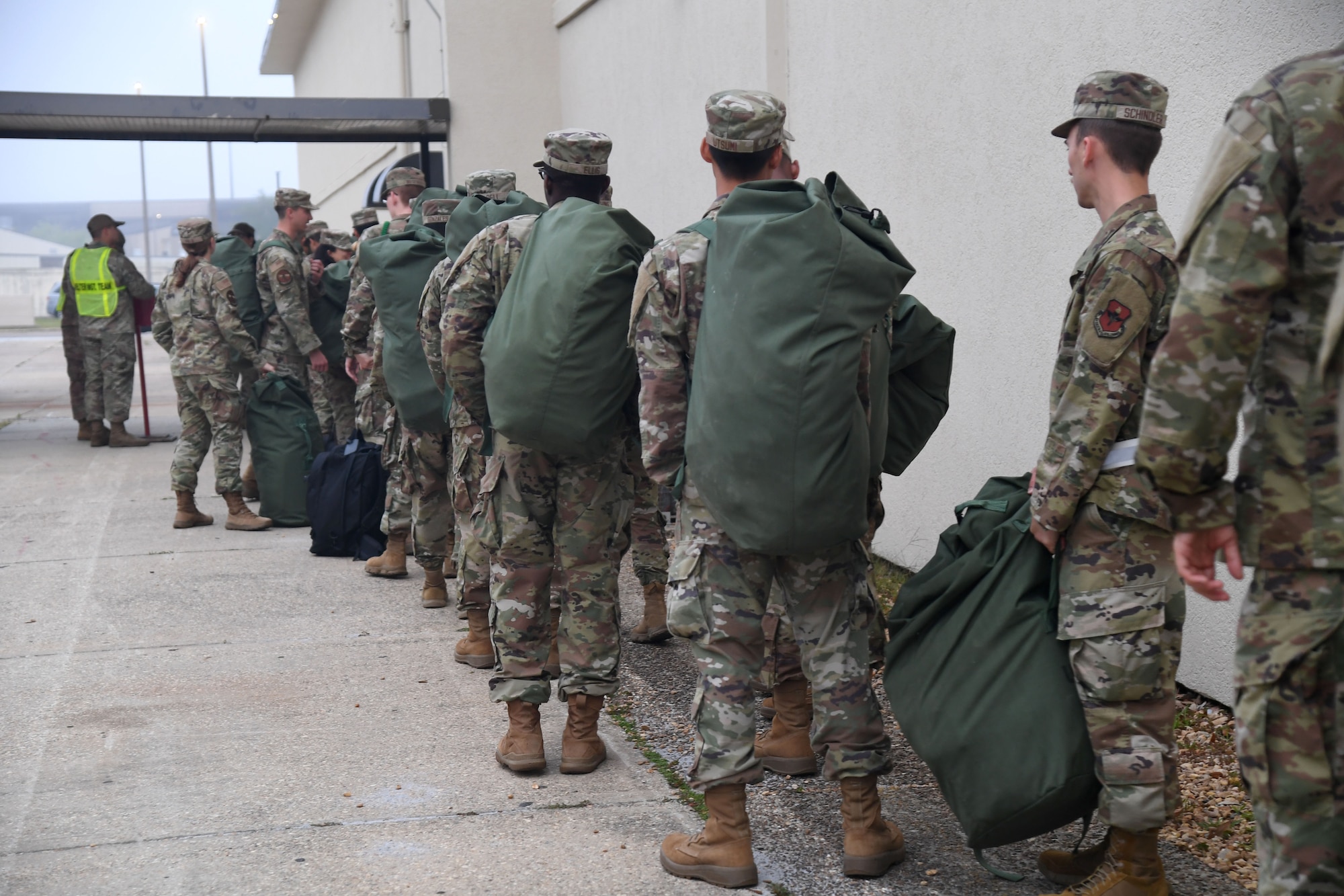 Airmen from the 81st Training Group line up outside of Allee Hall for shelter in-processing during a hurricane exercise at Keesler Air Force Base, Mississippi, April 29, 2022. Keesler personnel participate in exercise scenarios in preparation for hurricane season. (U.S. Air Force photo by Kemberly Groue)