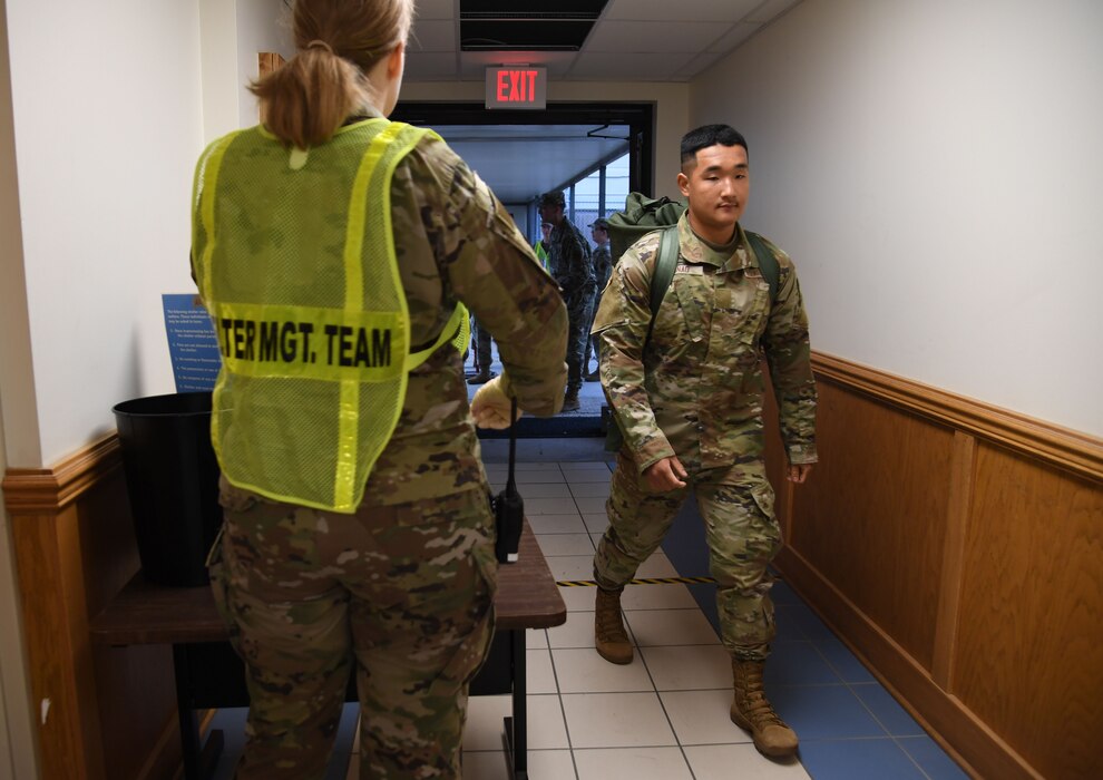 U.S. Air Force Airman Bunao Trey, 335th Training Squadron student, enters Allee Hall for shelter in-processing during a hurricane exercise at Keesler Air Force Base, Mississippi, April 29, 2022. Keesler personnel participate in exercise scenarios in preparation for hurricane season. (U.S. Air Force photo by Kemberly Groue)