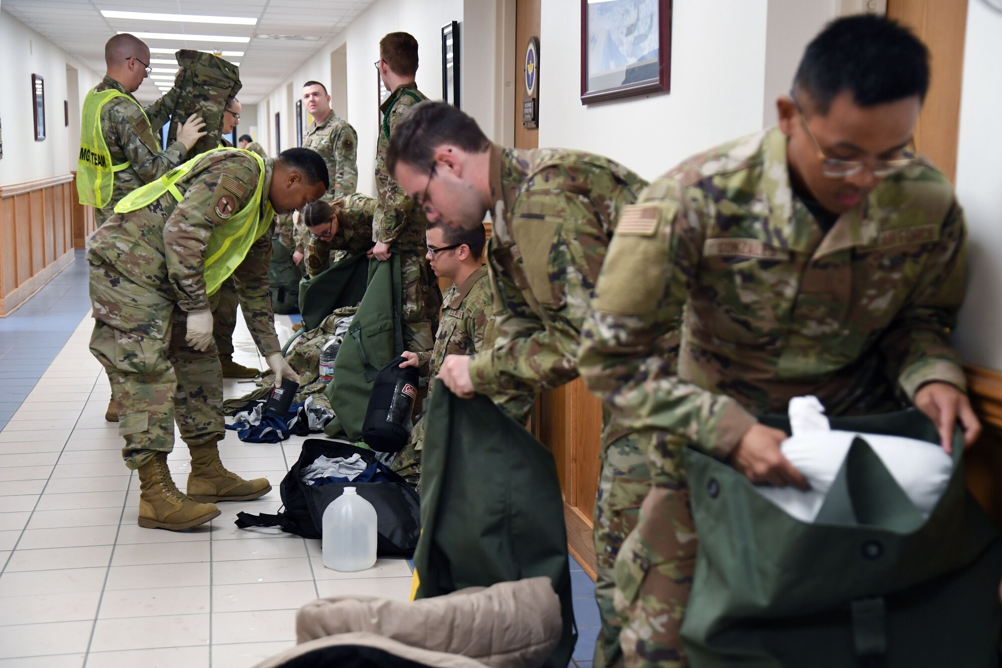 Members of the 335th Training Squadron sheltering team in-process Airmen into the Allee Hall shelter during a hurricane exercise at Keesler Air Force Base, Mississippi, April 29, 2022. Keesler personnel participate in exercise scenarios in preparation for hurricane season. (U.S. Air Force photo by Kemberly Groue)