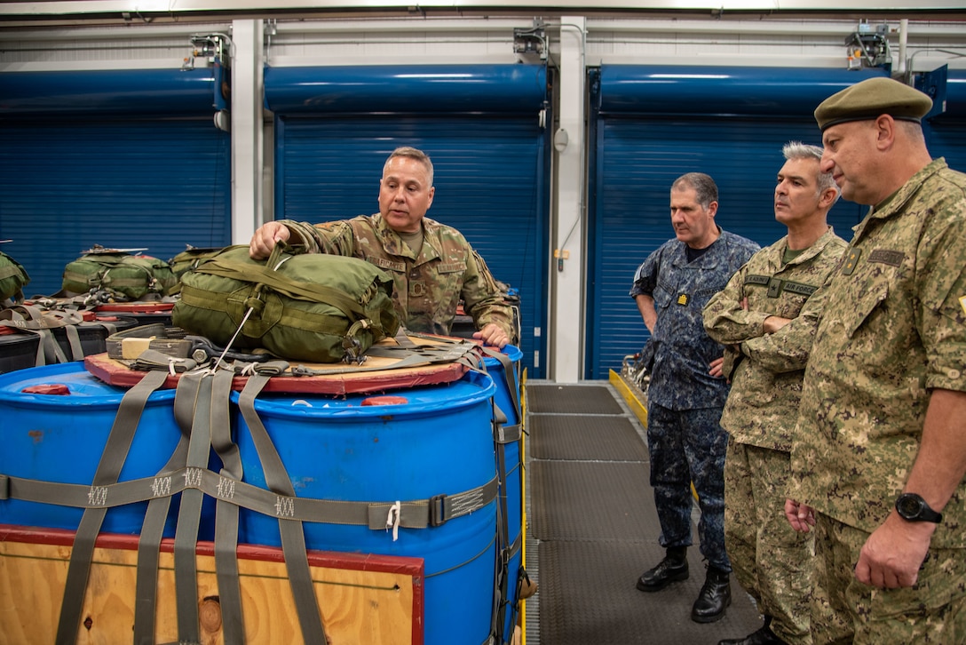 Command CMSgt James Traficante demonstrates cargo webbing used for airdrop operations for Uruguayan Army Maj. Gen. Hugo Rebollo at the 103rd Airlift Wing's Small Air Terminal in Windsor Locks, Conn. on June 15, 2021. The visit was part of a bilateral State Partnership Program engagement between the Armed Forces of Uruguay and the Connecticut National Guard.