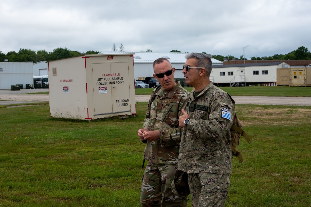 Uruguayan Air Force Col. Ruben Aquines and U.S. Air Force Col. Tom Olander discuss security cooperation en route to a UH-60M Blackhawk at the 1109th TASMG in Groton, Conn. on June 15, 2021. The visit was part of a bilateral State Partnership Program engagement.