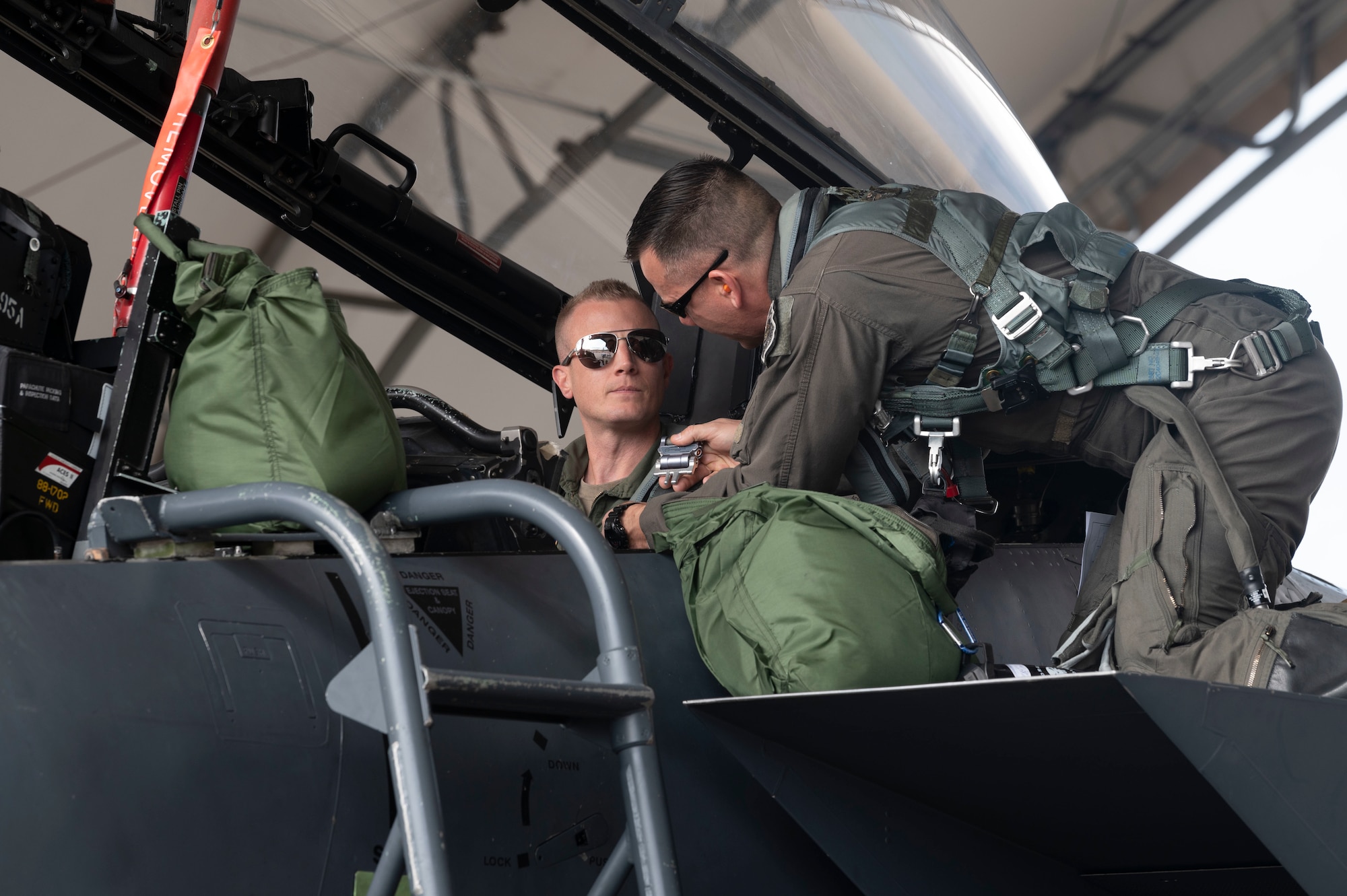 Col. Kurt Helphinstine, 4th Fighter Wing commander, helps SrA Garret Ford, 704th Aircraft Maintenance Squadron crew chief, with familiarization of the F-15E Strike Eagle cockpit at Seymour Johnson Air Force Base, North Carolina, May 2, 2022. Col. Helphinstine flew his last flight in the F-15E while taking Ford up for his first flight. (U.S. Air Force photo by Senior Airman Kevin Holloway)