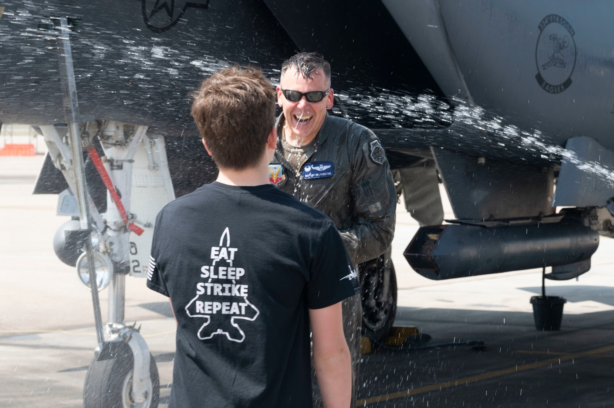 Col. Helphinstine, 4th Fighter Wing commander, gets sprayed with water by his family after he returns from his final flight at Seymour Johnson Air Force Base, North Carolina, May 2, 2022. Traditionally, air crew get sprayed down after their final flight. (U.S. Air Force photo by Senior Airman Kevin Holloway)