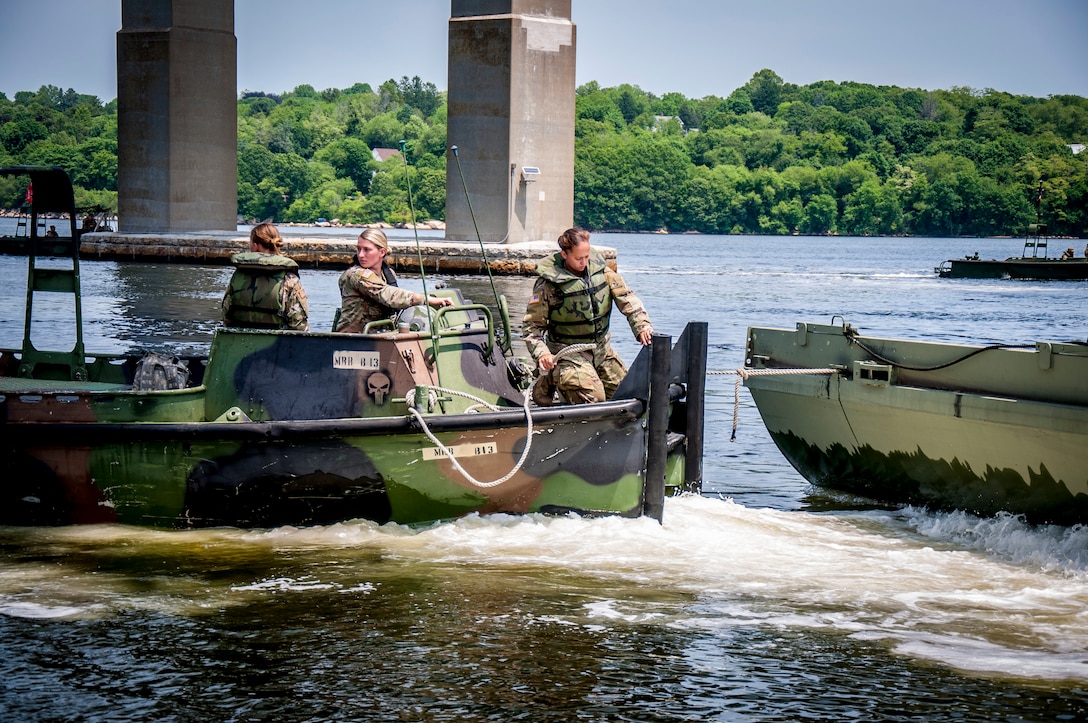 Soldiers assigned to the Connecticut National Guard's 250th Multi-Role Bridge Company drive their Bridge Erection Boat into position to grab a section of a Improved Ribbon Bridge on the Thames River in New London, Connecticut, June 10, 2020. The IRB team practiced creating a five-float raft which is designed to transport troops, equipment, and vehicles across a river.