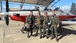 Two instructor pilots and two student pilots with Training Squadron (VT) 28 responded to a distress call from Corpus Christi International Airport air traffic control and guided a civilian pilot to a safe landing at Mustang Beach Airport, Dec. 13. Pictured with a T-6B Texan II on the Naval Air Station Corpus Christi flight line from left to right: Lt. Cmdr. Dave Indiveri, Succasunna, New Jersey; Marine 1st Lt. Casey Joehnk, Port Orchard, Washington; Ensign Christophe Theodore, San Francisco; and Lt. Billy Morse, Tucson, Arizona. (Courtesy photo)