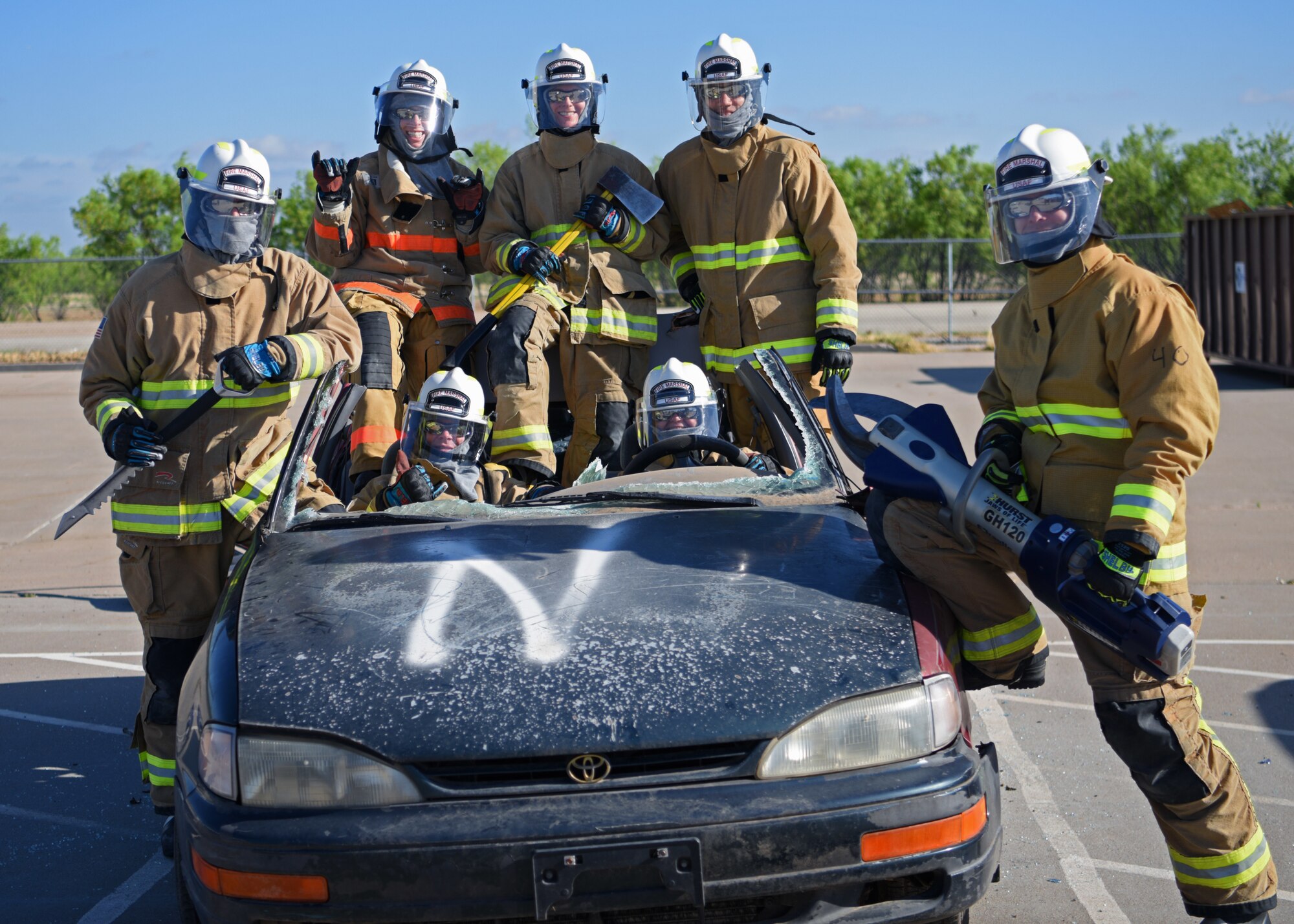 Fire marshals pose after completing a vehicle extraction exercise at the Louis F. Garland Department of Defense Fire Academy, Goodfellow Air Force Base, Texas, on April 20, 2022. The instructors showed the class different ways to remove a person from a vehicle, including breaking the windows and even removing the roof. The Fire Marshal course was designed to provide insight on the numerous responsibilities and challenges within Department of Defense Fire and Emergency Services to future civil engineer commanders. (U.S. Air Force photo by Senior Airman Ethan Sherwood)