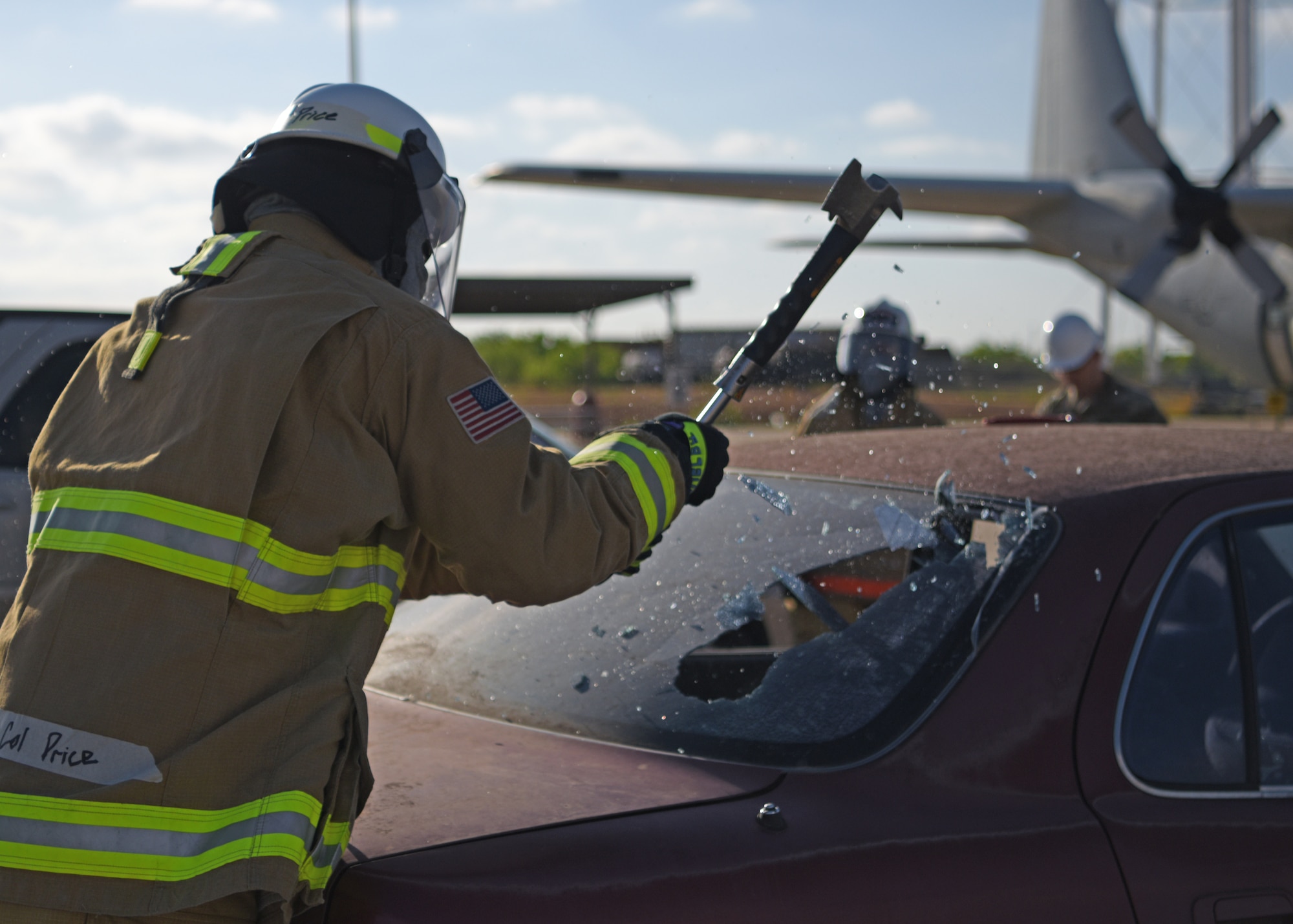 A fire marshal shatters the back window of a car during a vehicle extraction exercise at the Louis F. Garland Department of Defense Fire Academy, Goodfellow Air Force Base, Texas, April 20, 2022. Goodfellow hosted the Fire Marshal course to certify commanders as official fire marshals. The Fire Marshal course was designed to provide insight on the numerous responsibilities and challenges within Department of Defense Fire and Emergency Services to future civil engineer commanders.  (U.S. Air Force photo by Senior Airman Ethan Sherwood)