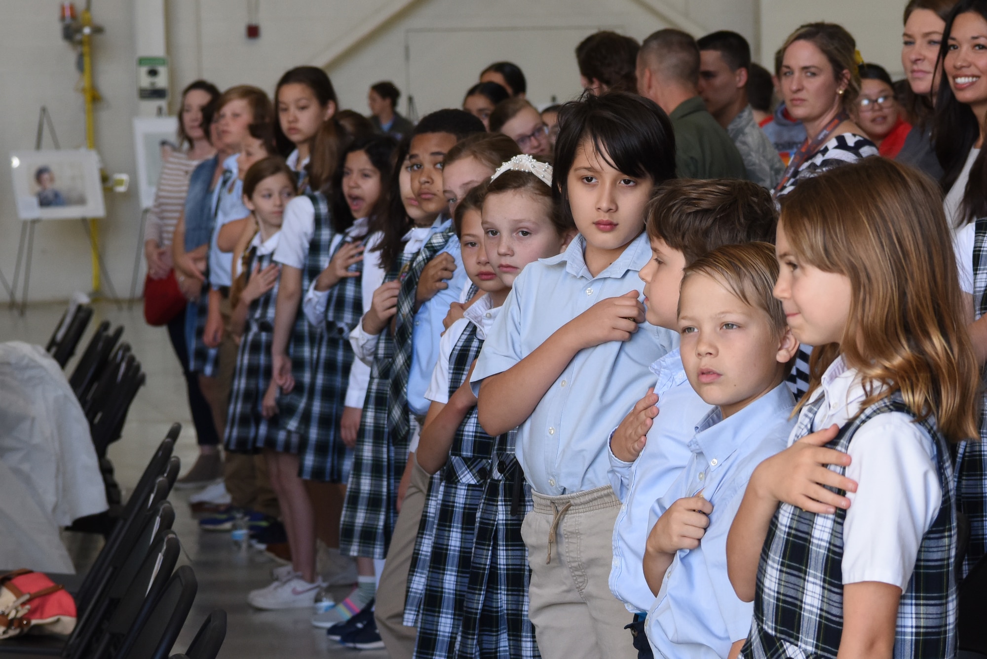 Students from St. John’s Episcopal School put their hands over their hearts during the national anthem at Dyess Air Force Base, Texas, April 29, 2022. The event marks the 80th anniversary for Women Airforce Service Pilots, or WASP, the 80th anniversary of the 317th Airlift Wing and the 80th anniversary of the 8th Air Force. (U.S. Air Force Photo by Senior Airman Sophia Robello)