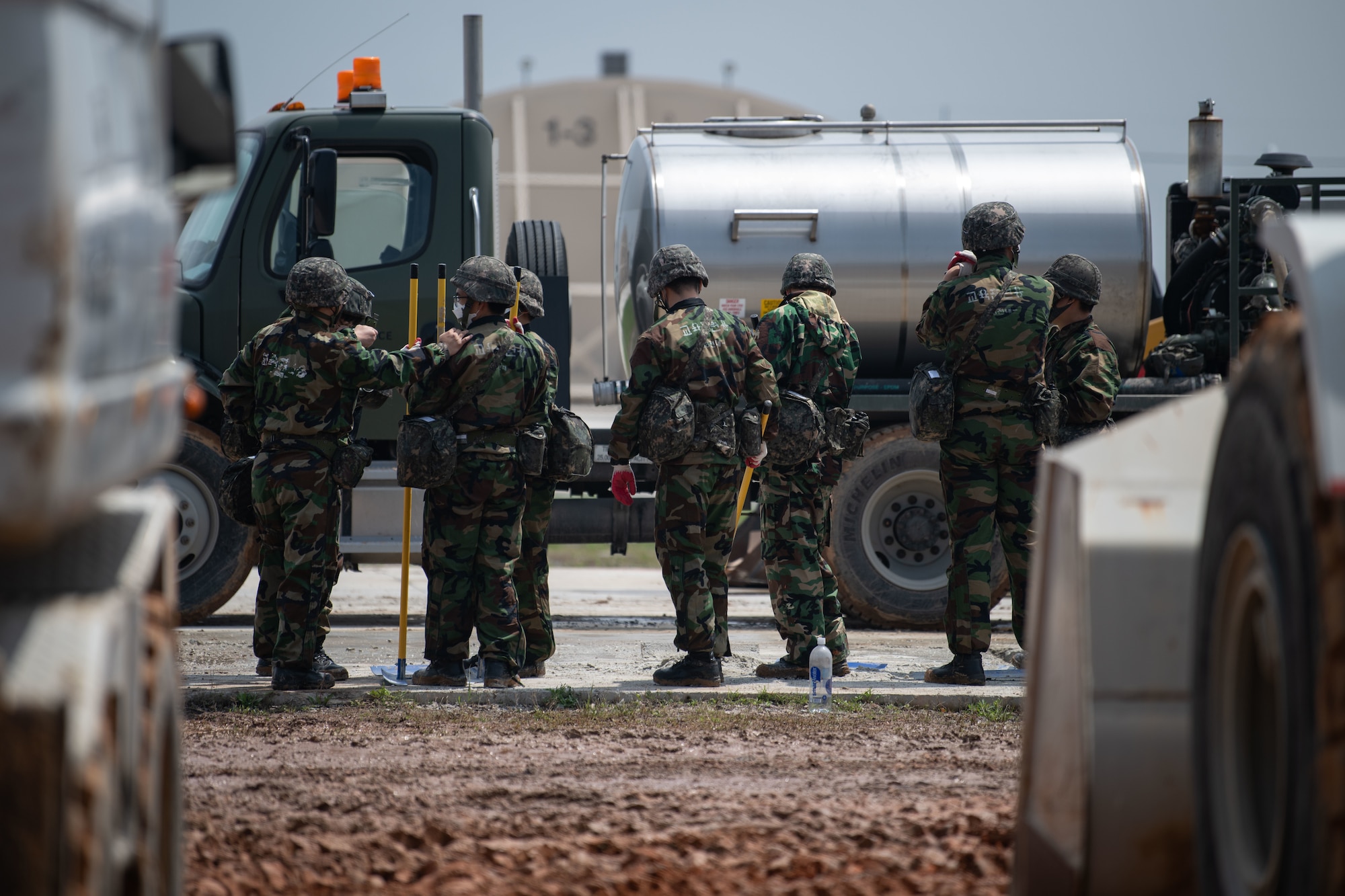Republic of Korea and U.S. Air Force members fill a simulated crater with water and concrete during Rapid Airfield Damage Repair (RADR) training at Kunsan Air Base, ROK, April 26, 2022.