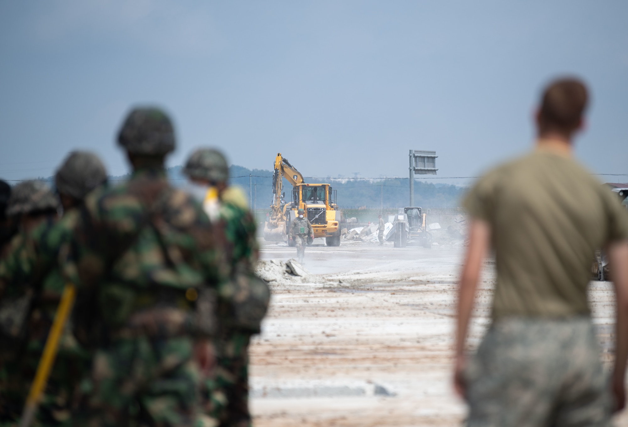 Republic of Korea and U.S. Air Force members fill a simulated crater with water and concrete during Rapid Airfield Damage Repair (RADR) training at Kunsan Air Base, ROK, April 26, 2022.