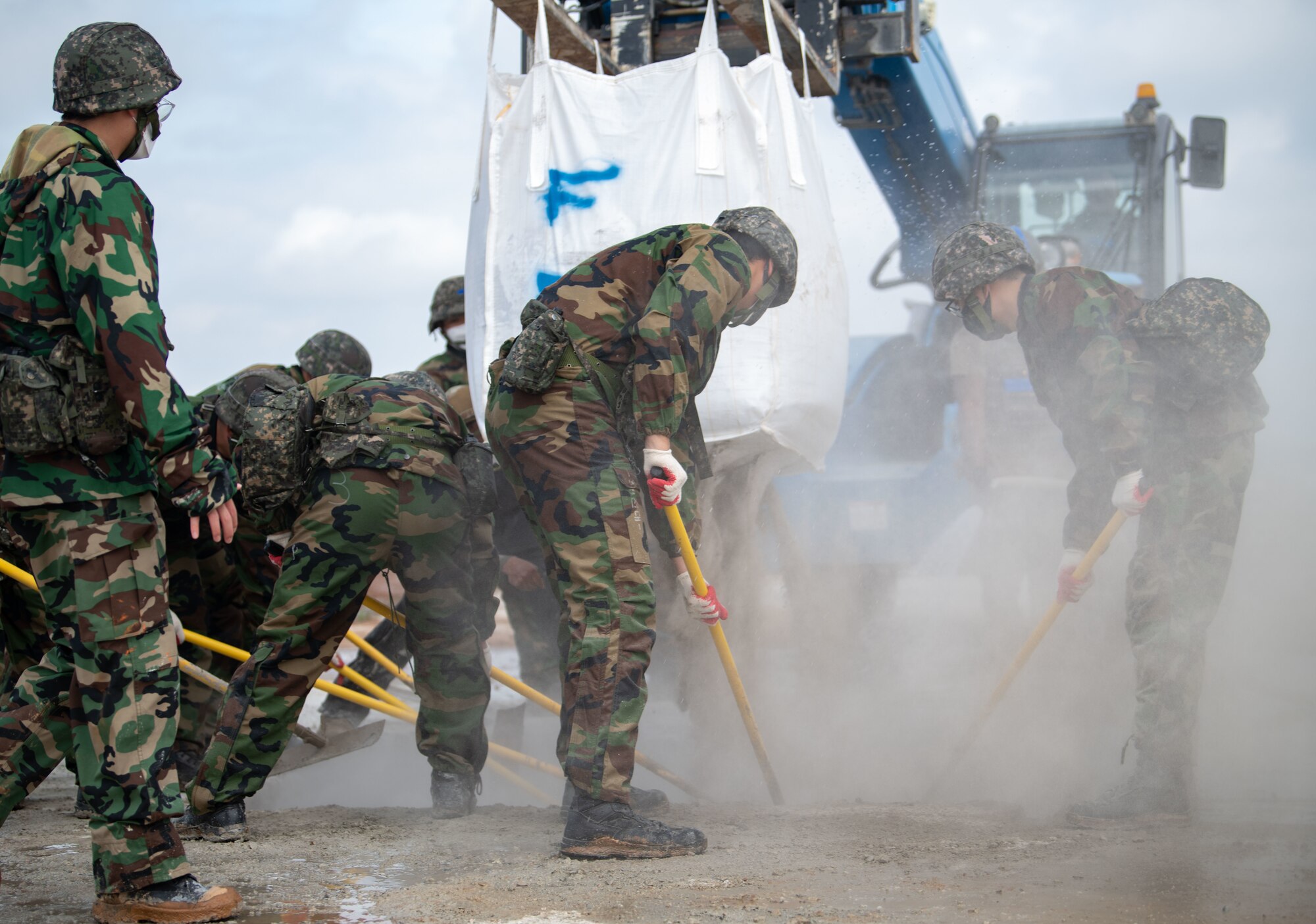 Republic of Korea and U.S. Air Force members fill a simulated crater with water and concrete during Rapid Airfield Damage Repair (RADR) training at Kunsan Air Base, ROK, April 26, 2022.