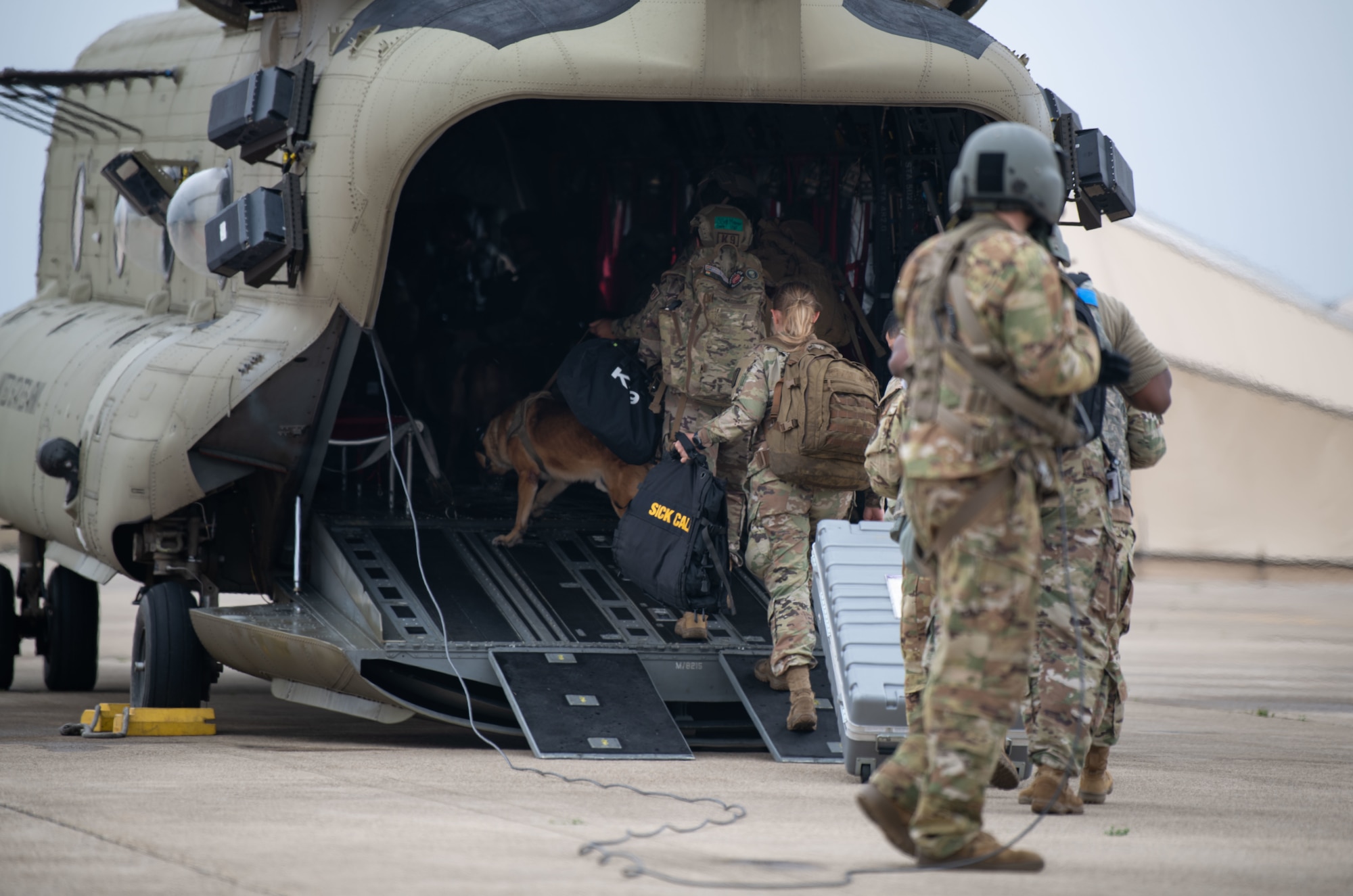 U.S. Air Force Airmen assigned to the 8th Fighter Wing and U.S. Army Soldiers assigned to the U.S. Army Bravo Company, 3-2 General Support Aviation Battalion, board a CH-47 Chinook helicopter during a K-9 medical evacuation training event at Kunsan Air Base, Republic of Korea, April 26, 2022. These trainings not only benefit the MWDs, but also helps the handlers, veterinary staff, aviation brigade personnel, and the 8th Medical Group reevaluate and develop processes for continuity and quick action responses in emergency scenarios. (U.S. Air Force photo by Staff Sgt. Gabrielle Spalding)