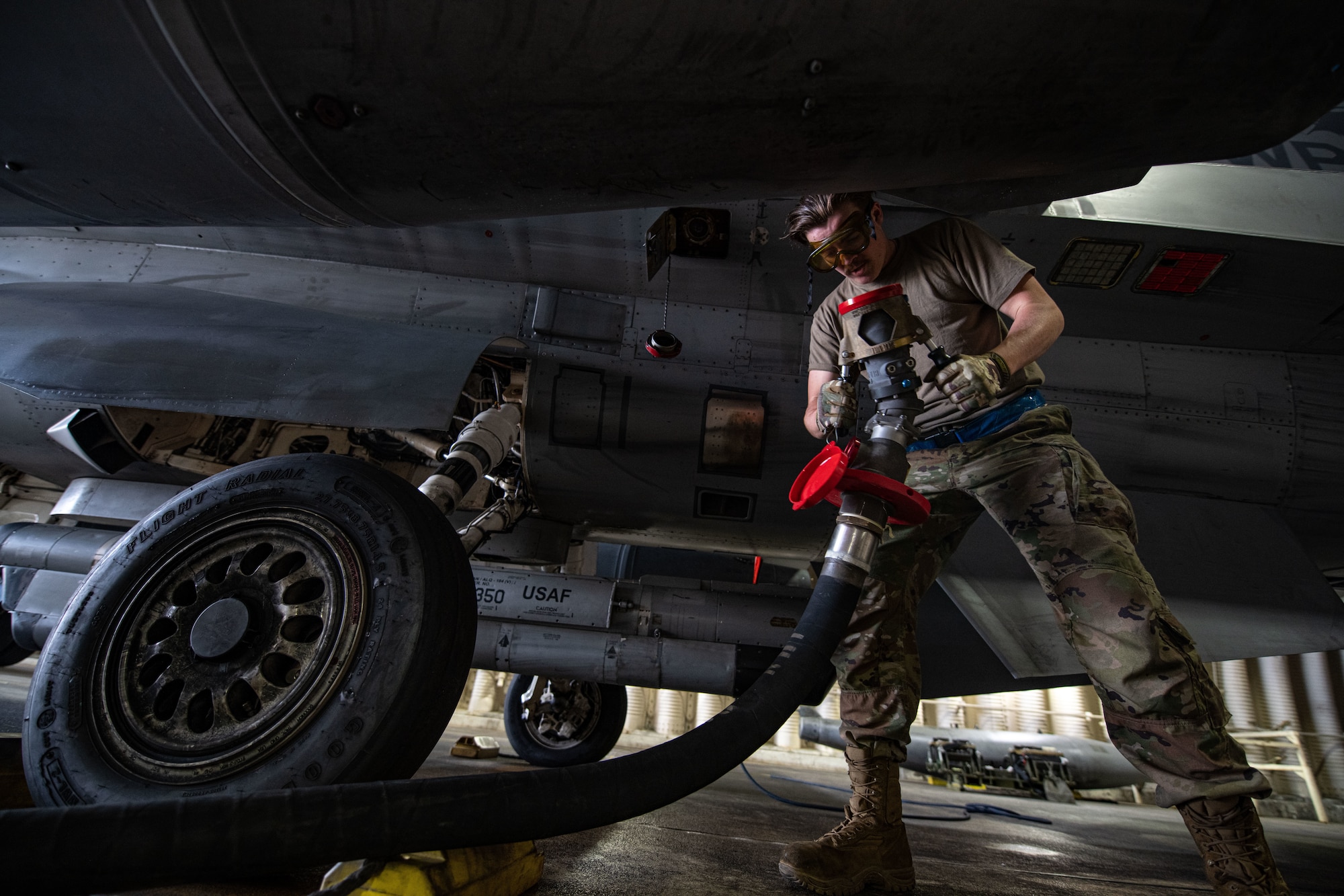 Senior Airman Ridge Logan, 8th Aircraft Maintenance Squadron crew chief, adjusts a fuel hose before attaching it to an F-16 Fighting Falcon at Kunsan Air Base, Republic of Korea, April 28, 2022. Crew chiefs work closely with 8th Logistics Readiness Squadron petroleum, oil and lubricants flight (POL) technicians to ensure the refueling process is completed accurately and effectively. (U.S. Air Force photo by Staff Sgt. Gabrielle Spalding)
