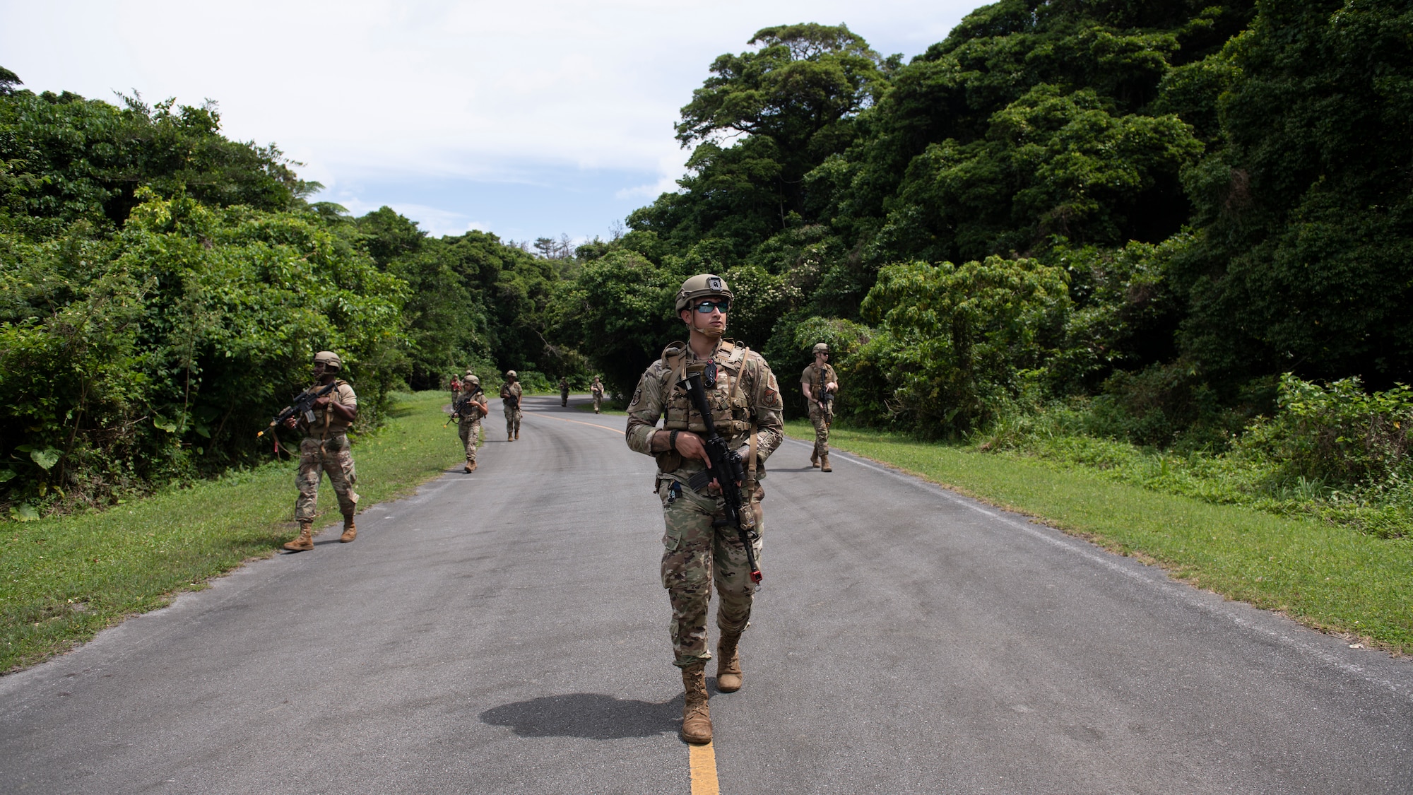 U.S. Air Force Airmen assigned to the 18th Security Forces Squadron patrol an area in a staggered column formation during a field training exercise at Kadena Air Base, Japan, April 27, 2022. The staggered column is a common military formation where squad members walk in a zig-zag pattern, often while traveling along open roads. (U.S. Air Force photo by Senior Airman Jessi Monte)