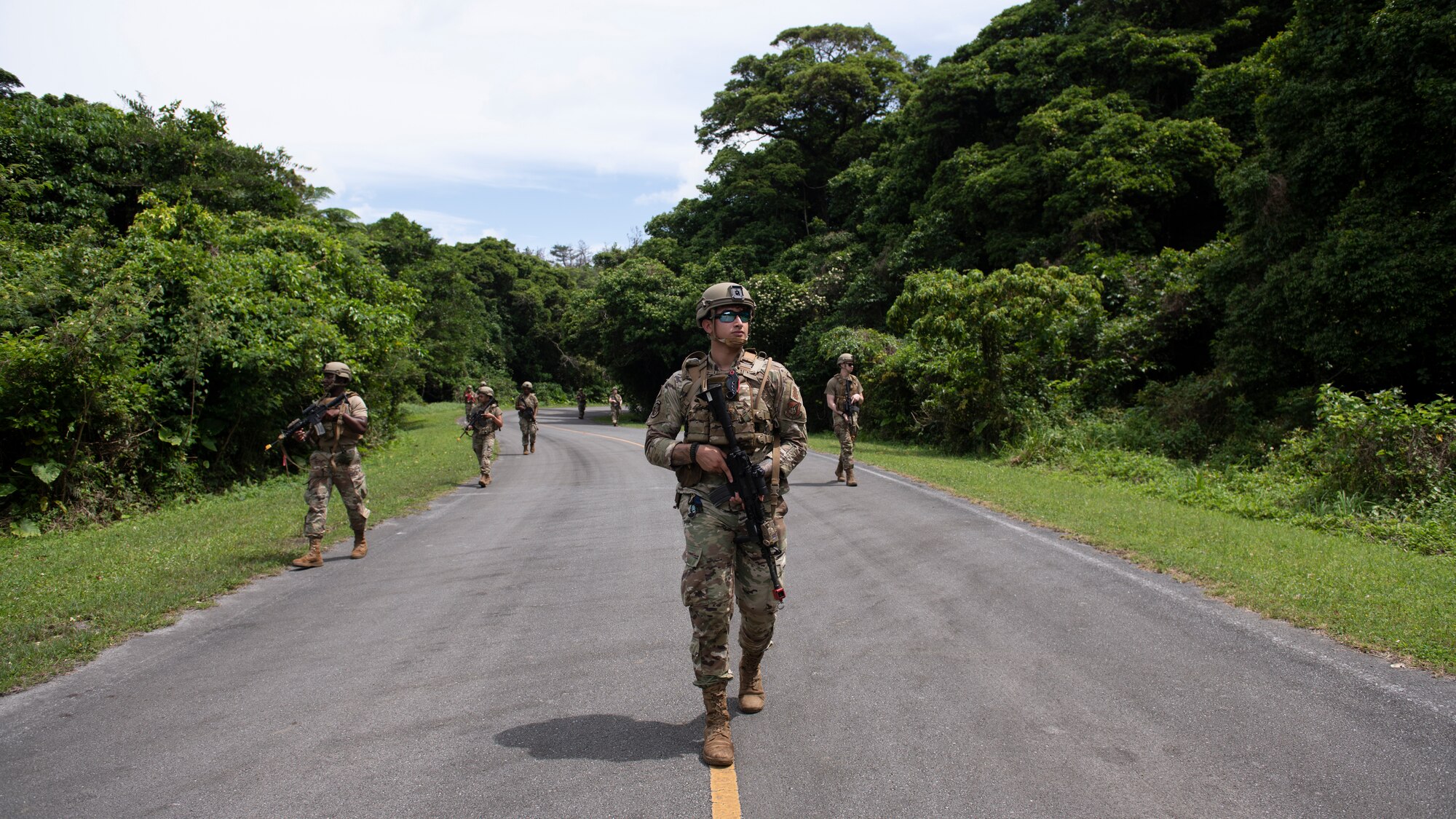 U.S. Air Force Airmen assigned to the 18th Security Forces Squadron patrol an area in a staggered column formation during a field training exercise at Kadena Air Base, Japan, April 27, 2022. The staggered column is a common military formation where squad members walk in a zig-zag pattern, often while traveling along open roads. (U.S. Air Force photo by Senior Airman Jessi Monte)