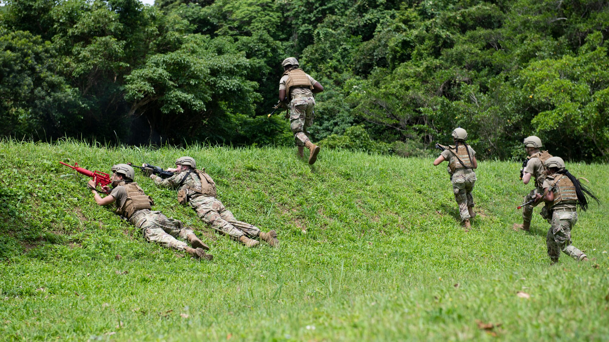 U.S. Air Force Airmen assigned to the 18th Security Forces Squadron engage with opposing forces during a field training exercise at Kadena Air Base, Japan, April 27, 2022. The Airmen were faced with unexpected hostile encounters, training their ability to effectively respond and communicate with team members in a simulated combat environment. (U.S. Air Force photo by Senior Airman Jessi Monte)
