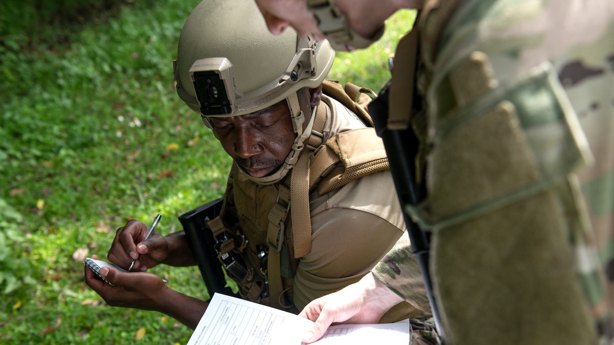 U.S. Air Force Airmen assigned to the 18th Security Forces Squadron discuss reconnaissance information during a field training exercise at Kadena Air Base, Japan, April 27, 2022. The Airmen were required to use land navigation techniques to reach their objective. (U.S. Air Force photo by Senior Airman Jessi Monte)