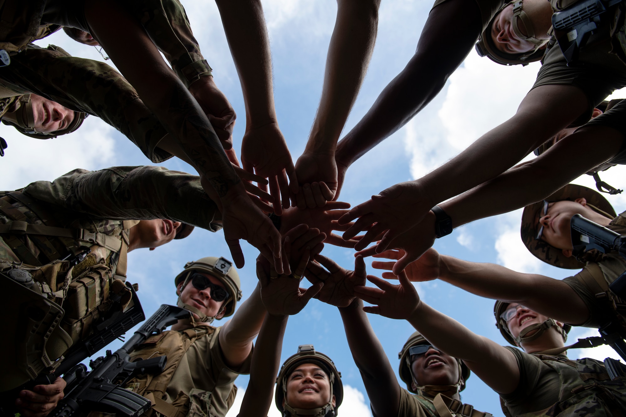 U.S. Air Force Airmen assigned to the 18th Security Forces Squadron huddle before a field training exercise at Kadena Air Base, Japan, April 27, 2022. The training is an annual requirement for all SFS members, covering traveling techniques, movement formations, and using cover and concealment to advance on or defend objectives. (U.S. Air Force photo by Senior Airman Jessi Monte)