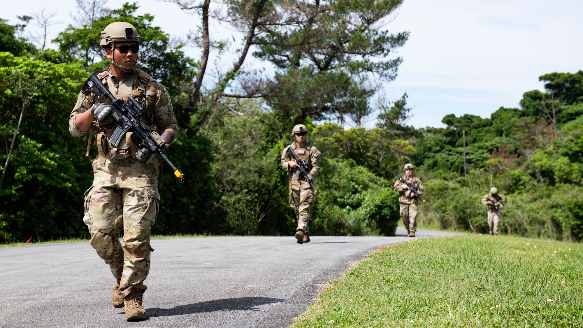 U.S. Air Force Airmen assigned to the 18th Security Forces Squadron patrol an area in a staggered column formation during a field training exercise at Kadena Air Base, Japan, April 27, 2022. The staggered column is a common military formation where squad members walk in a zig-zag pattern, often while traveling along open roads. (U.S. Air Force photo by Senior Airman Jessi Monte)