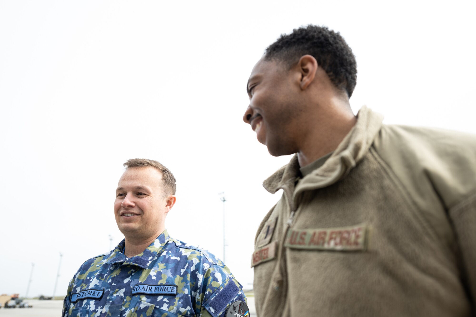 Romanian air force and U.S. Air Force lieutenants stand next to each other.