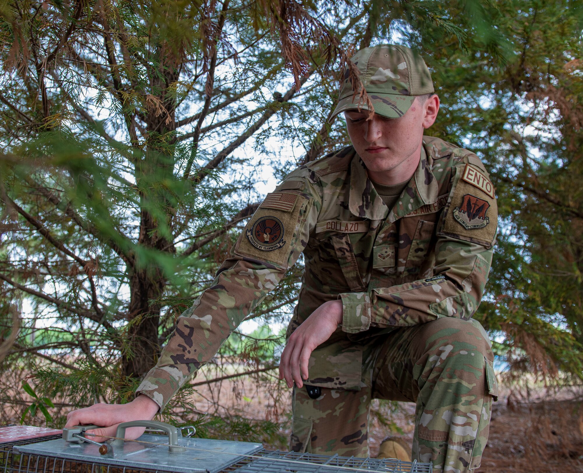 Airman 1st Class Jordan Collazo, 4th Civil Engineer Squadron pest management apprentice, sets up an animal trap at Seymour Johnson Air Force Base, North Carolina, May 3, 2022. Pest management works to prevent the increasing number of insects and animals by removing or relocating wildlife from the area before it negatively impacts the mission. (U.S. Air Force photo by Airman 1st Class Sabrina Fuller)