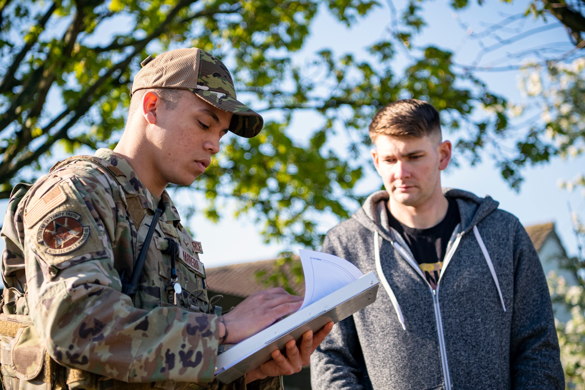 U.S. Air Force Airman 1st Class Trystan Marrero, left, 423d Security Forces Squadron patrolman, writes down a statement from a field training exercise participant at RAF Alconbury, England, April 26, 2022. The exercise was designed to evaluate the strengths and weaknesses of 423d SFS members' response to various scenarios including domestic disturbances, drunk driving and other base security incidents. (U.S. Air Force photo by Staff Sgt. Eugene Oliver)