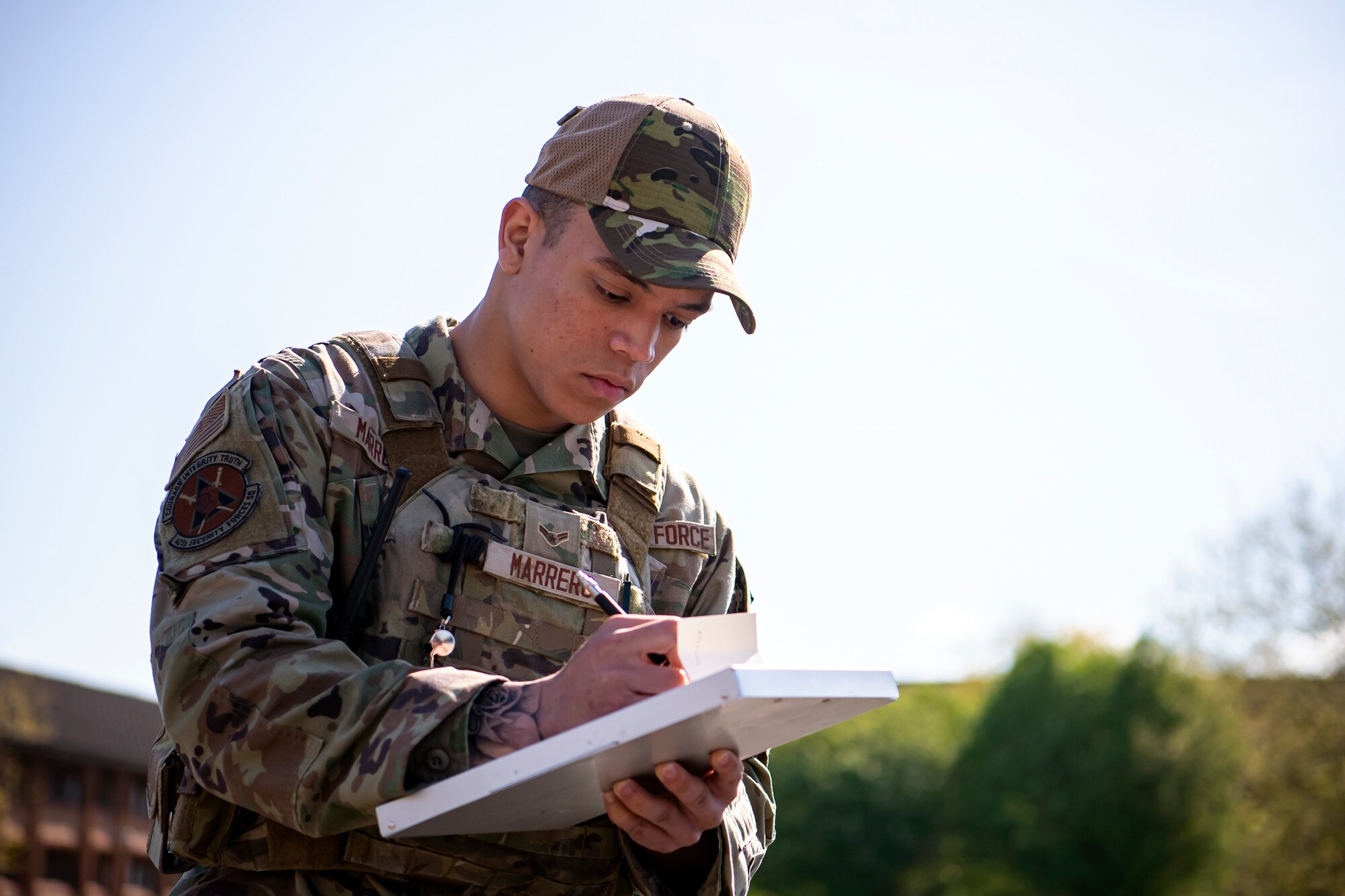 U.S. Air Force Airman 1st Class Trystan Marrero, left, 423d Security Forces Squadron patrolman, writes notes during a field training exercise at RAF Alconbury, England April 26, 2022. The exercise was designed to evaluate the strengths and weaknesses of 423d SFS members' response to various scenarios including domestic disturbances, drunk driving and other base security incidents. (U.S. Air Force photo by Staff Sgt. Eugene Oliver)