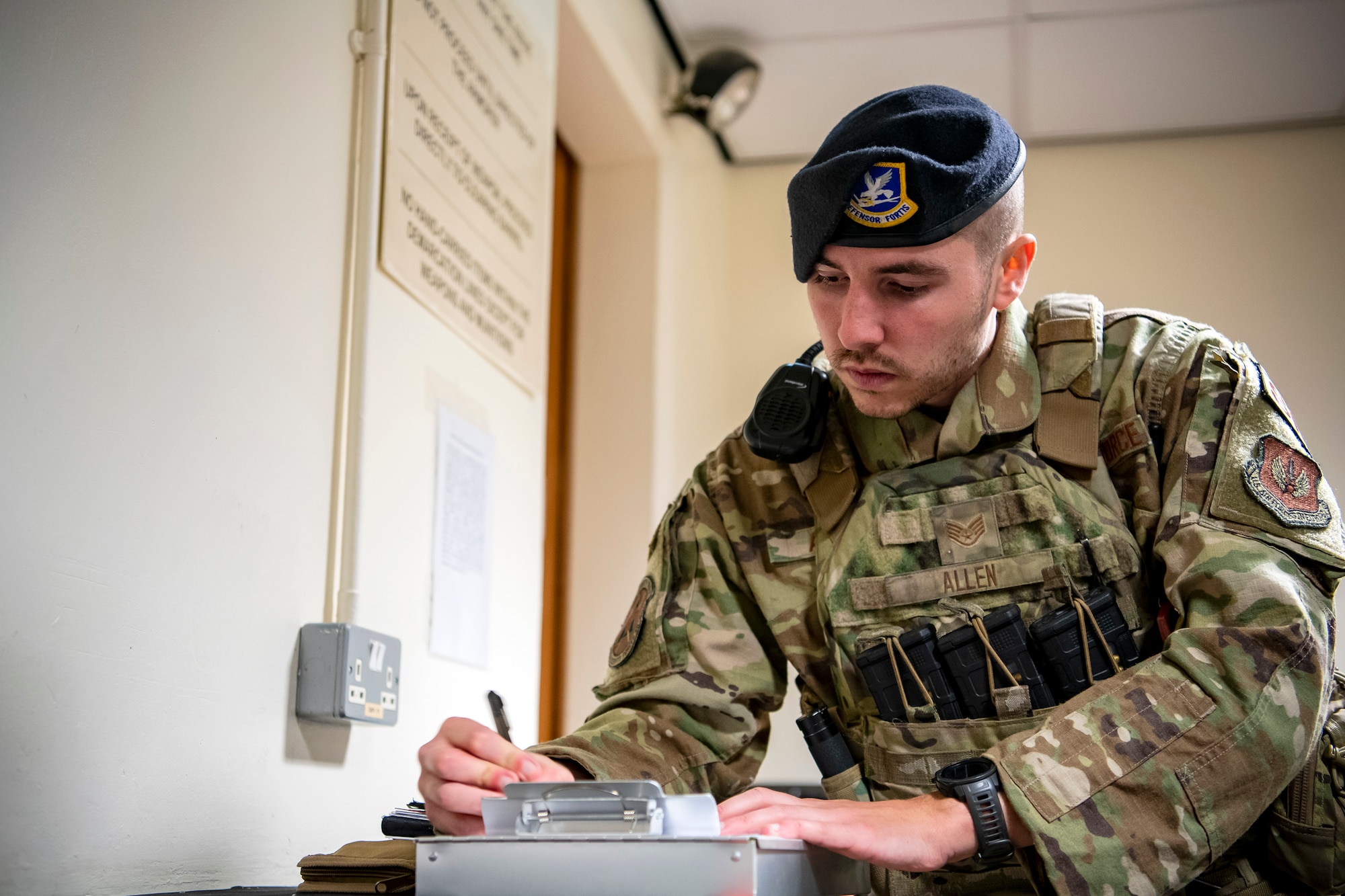 U.S. Air Force Staff Sgt. Elijah Allen, 423d Security Forces Squadron flight sergeant, writes notes during a field training exercise at RAF Molesworth, England, April 27, 2022. The exercise was designed to evaluate the strengths and weaknesses of 423d SFS members' response to various scenarios including domestic disturbances, drunk driving and other base security incidents. (U.S. Air Force photo by Staff Sgt. Eugene Oliver)