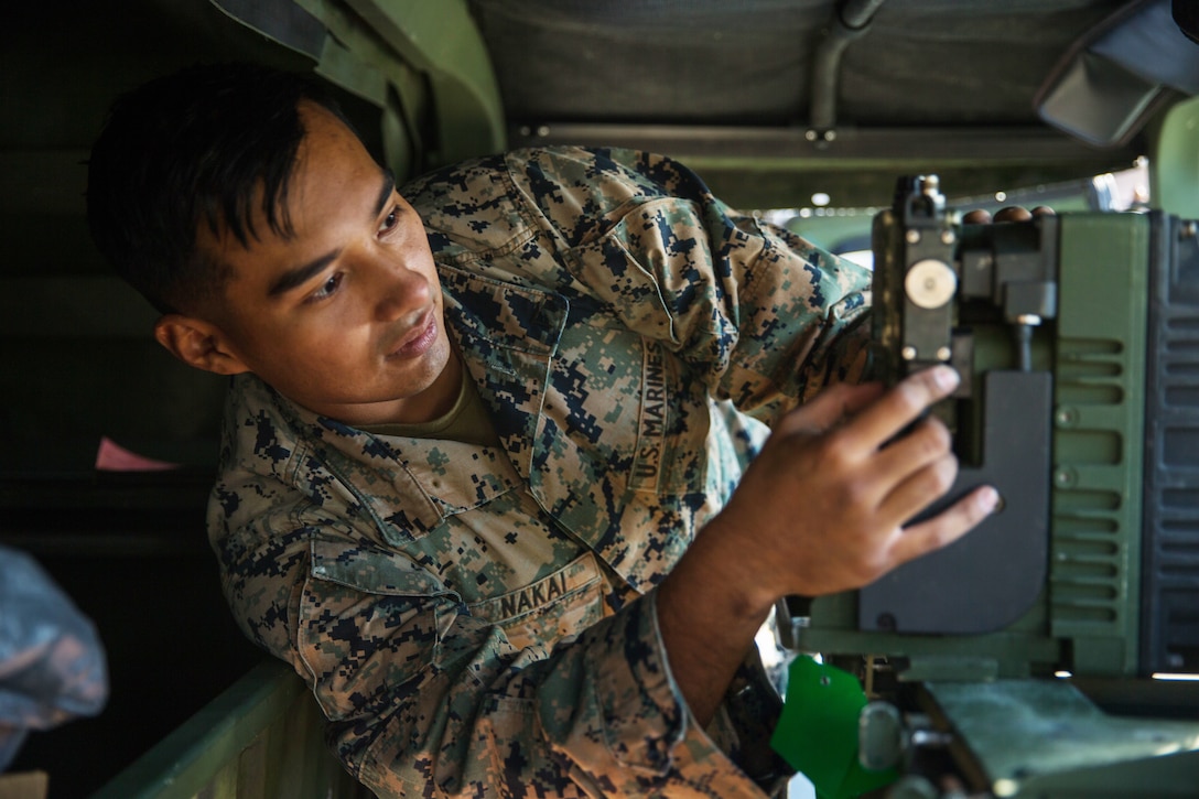 Close u of a male in a camo uniform holding equipment