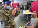 U.S. Air Force Capt. Alejandro Bautista readies a COVID-19 vaccination for U.S. Army Sgt Maj. Joseph Fisher at the Camp Smith Training Site Medical Readiness Clinic, N.Y., Dec.16, 2020. The New York Army National Guard was recently recognized for having the best overall medical readiness for large state forces during fiscal 2021.