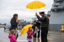 Cmdr. Joseph J. Gunta, executive officer of the Arleigh Burke-class guided-missile destroyer USS John S. McCain (DDG 56), greets his family after arriving at Naval Station Everett, Washington, October 16, 2021. The homecoming marks a new homeport change after 24 years of forward deployment in the U.S. 7th fleet. (U.S. Navy Photo by Mass Communication 2nd Class Victoria Galbraith)