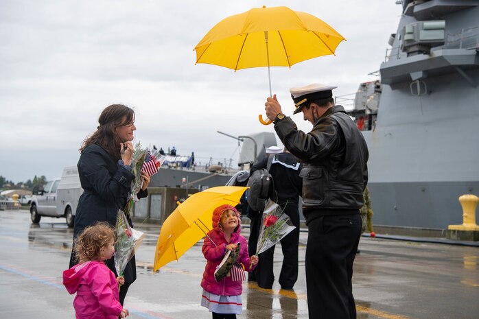 Cmdr. Joseph J. Gunta, executive officer of the Arleigh Burke-class guided-missile destroyer USS John S. McCain (DDG 56), greets his family after arriving at Naval Station Everett, Washington, October 16, 2021. The homecoming marks a new homeport change after 24 years of forward deployment in the U.S. 7th fleet. (U.S. Navy Photo by Mass Communication 2nd Class Victoria Galbraith)