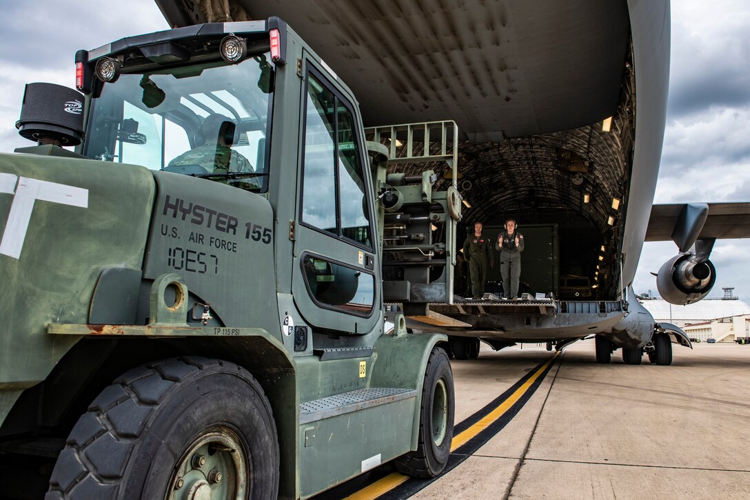 Airman Makennah Sawyer, 97th Training Squadron loadmaster student, directs a forklift offloading cargo from a C-17 Globemaster III while being evaluated by Tech Sgt. Jacob Wright, 58th Airlift Squadron loadmaster evaluator, at Joint Base San Antonio-Kelly Field, Texas, April 27, 2022. The 97th Air Mobility Wing deployed C-17’s, aircrew and support personnel from Altus Air Force Base, Okla. to Kelly Field, as part of Task Force Red Mammoth, which ensures the unit can provide global reach for combat and contingency operations while continuing training in a mobile environment. (U.S. Air Force photo by Brian J. Valencia)