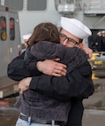 A Sailor reunites with his family after Arleigh Burke-class guided-missile destroyer USS McCampbell (DDG 85) arrived to its new homeport of Naval Station Everett, Washington April 8, 2022. Prior to relocating, the ship underwent an extensive Depot Modernization Period in Portland, Oregon that spanned more than 18 months. The modernization included improvements to the hull, mechanical systems, electrical technology, wireless communications, and weapon upgrades. This routine maintenance ensures the ship can continue to be mission capable throughout its expected service life. (U.S. Navy photo by Mass Communication Specialist 2nd Class Ethan Soto)