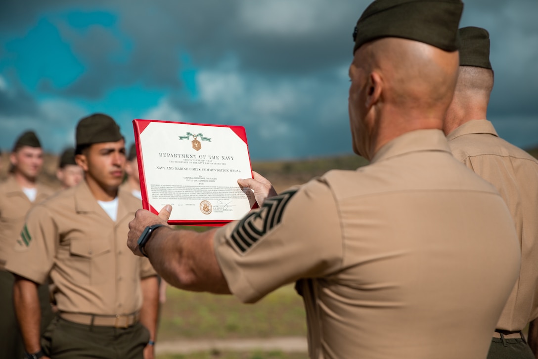 U.S. Marine Sgt. Maj. Eric Darmstadt, the battalion sergeant major of Headquarters and Support Battalion, Marine Corps Base Camp Pendleton, reads an award citation for Cpl. Giovanni Brunacini, a rifleman with Echo Company, 2nd Battalion, 5th Marine Regiment, 1st Marine Division, at Range 214 on Camp Pendleton, California, April 22, 2022. Brunacini, who is currently serving as a block noncommissioned officer with MCB Camp Pendleton’s Range Operations Division, earned a Navy and Marine Corps Commendation Medal for heroic actions taken after he helped save the life of a man wounded in a drive-by shooting in Lemon Grove, California. (U.S. Marine Corps photo by Lance Cpl Hope Straley)