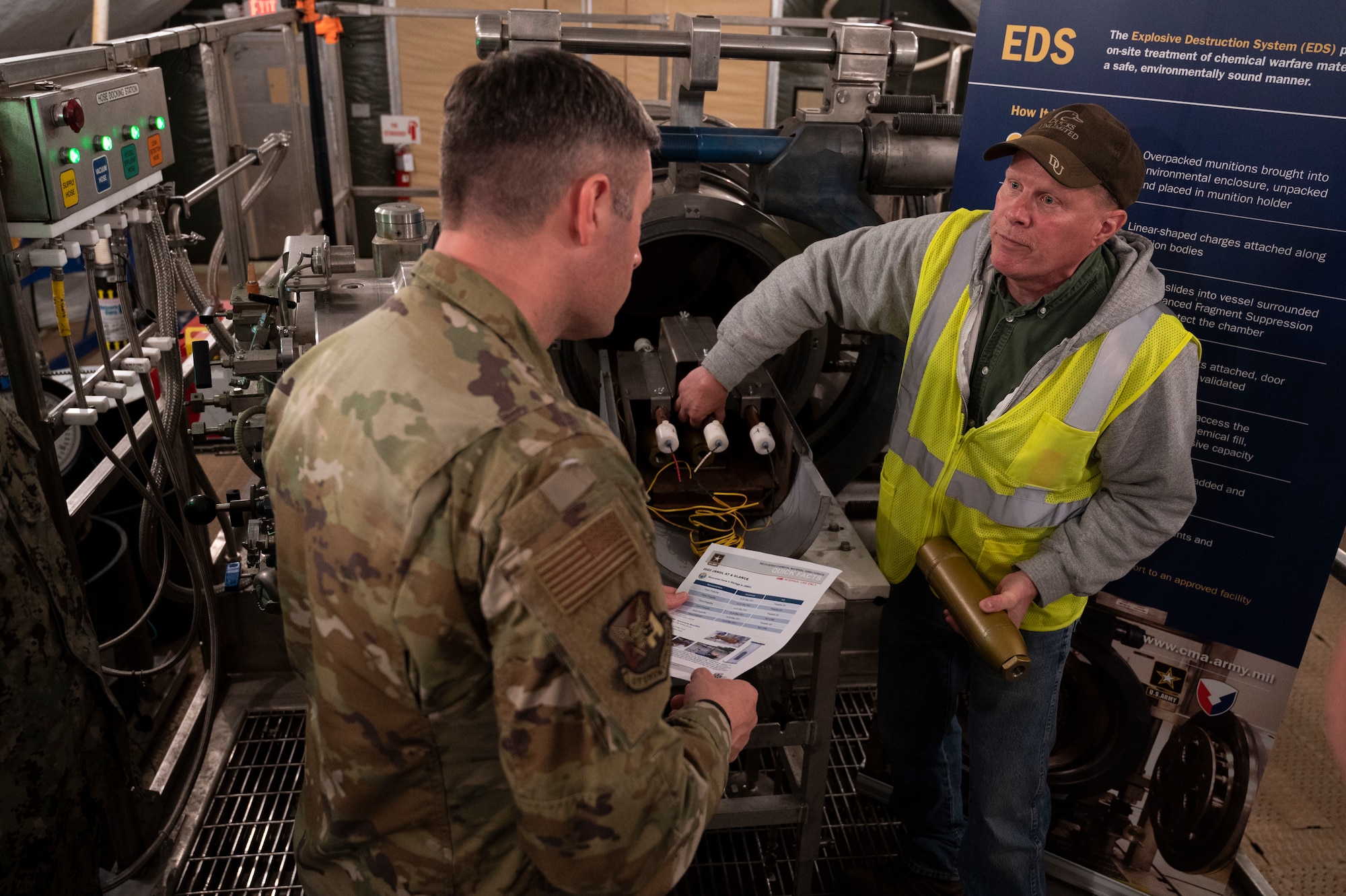 U.S. Air Force Col. Wes Adams, Joint Base McGuire-Dix-Lakehurst and 87th Air Base Wing commander, read a fact sheet while briefed on the process of explosive destruction and assessments during a tour of the destruction site hosted by the Recovered Chemical Materiel Directorate, May 2, 2022, on Joint Base MDL, New Jersey. RCMA partnered with Joint Base MDL for a second mission to destroy World War I-era chemical munitions after discovering a six 75mm projectiles at Joint Base MDL’s Parachute Jump Circle while investigating and removing chemical munitions, munitions of explosive concern and/or munitions constituents from two disposal pits. (U.S. Air Force photo by Staff Sgt. Ariel Owings)
