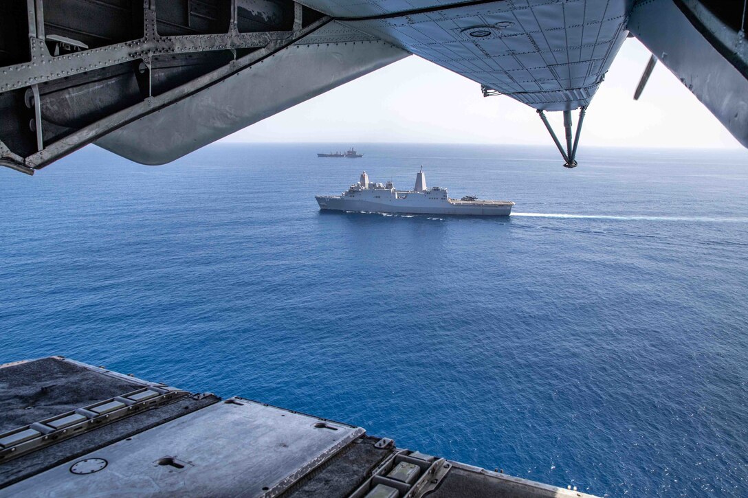Two ships at sea are seen from the tail of an aircraft.