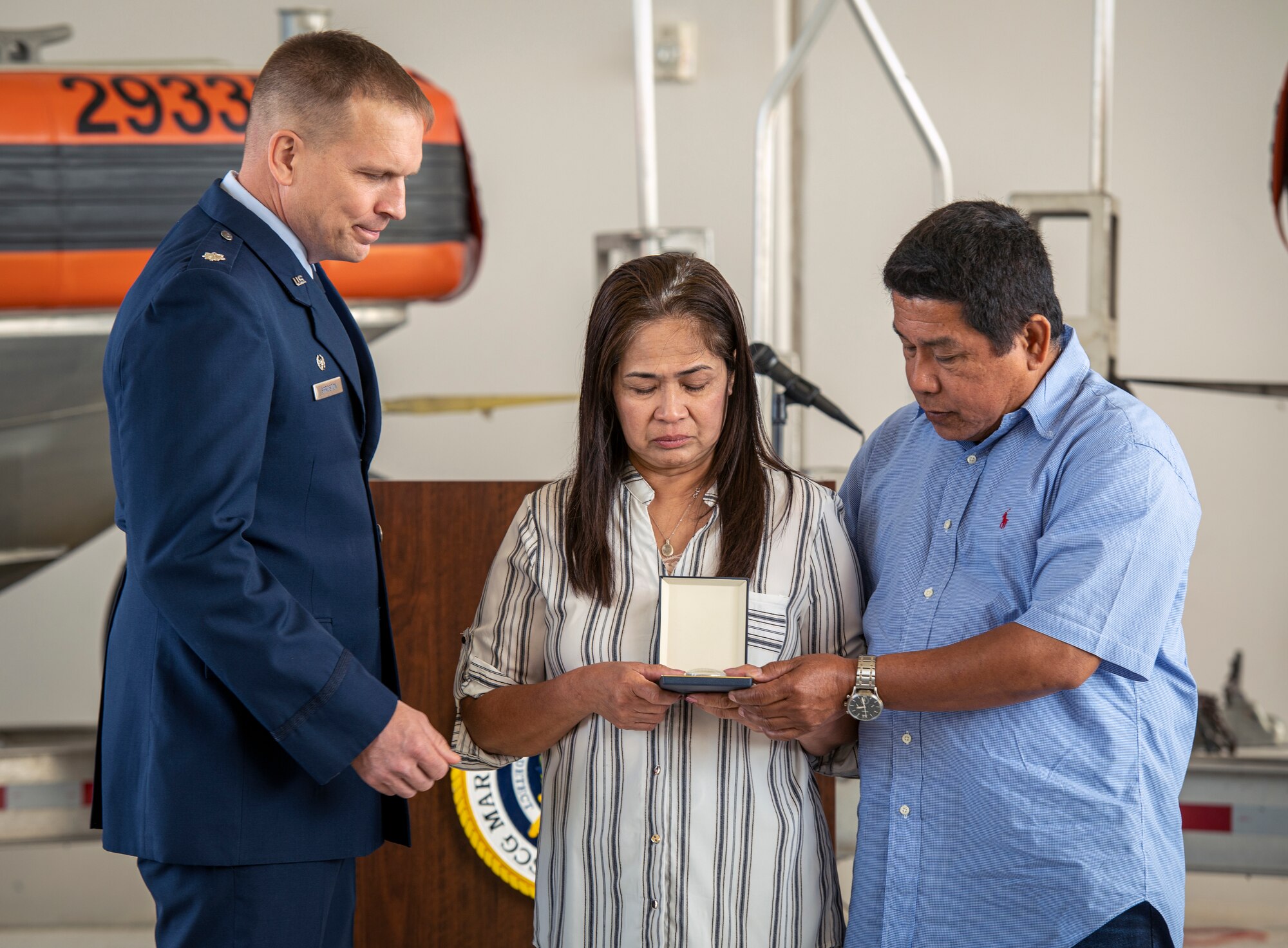 Jessica Reyes Posana and Erneto Posana accept the Airman’s Medal on behalf of their son, Elijah Posana, during a ceremony at Coast Guard Marine Safety Security Team Houston, Texas, April 26, 2022. Air Force Lt. Col. Devin L. Sproston, commander of the 509th Security Forces Squadron at Whiteman Air Force Base, Missouri, presented the medal and lauded Posana’s heroic rescue of his cousins from a rip current on Surfside Beach, Texas, May 2, 2021. (U.S. Coast Guard photo by Petty Officer 1st Class Corinne Zilnicki)