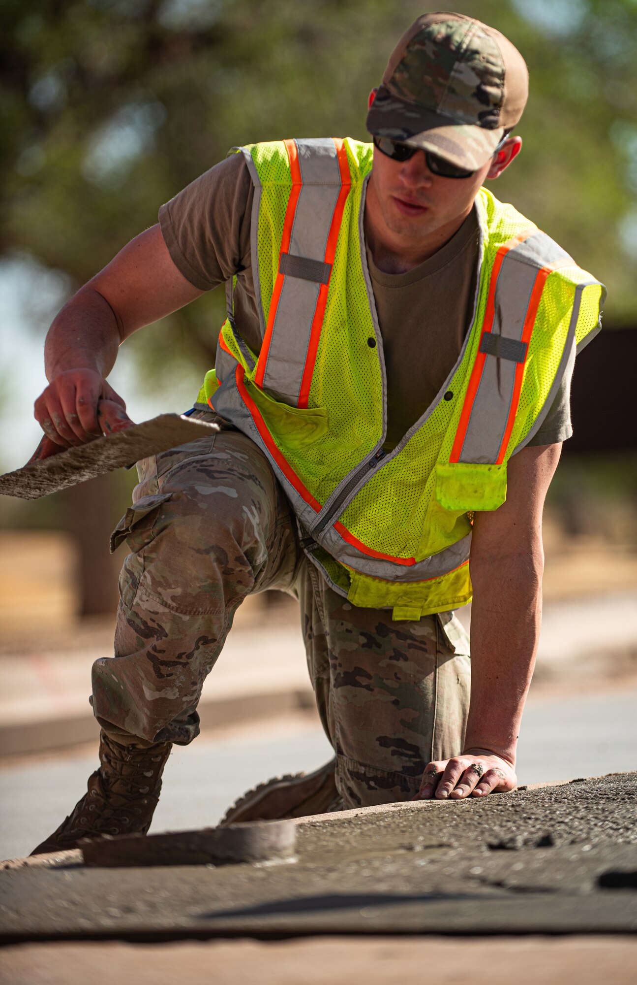 U.S Airman helps to reduce cracks by forming indentions in the concrete.