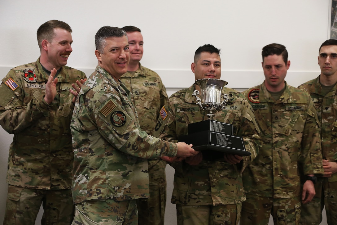 Maj. Gen. Torrence Saxe, adjutant general of the Alaska National Guard, presents the Governor’s Trophy to Golf Company, Detachment 2, 2-211th General Support Aviation Battalion in an award ceremony held at Bryant Army Airfield, Alaska, April 29, 2022.