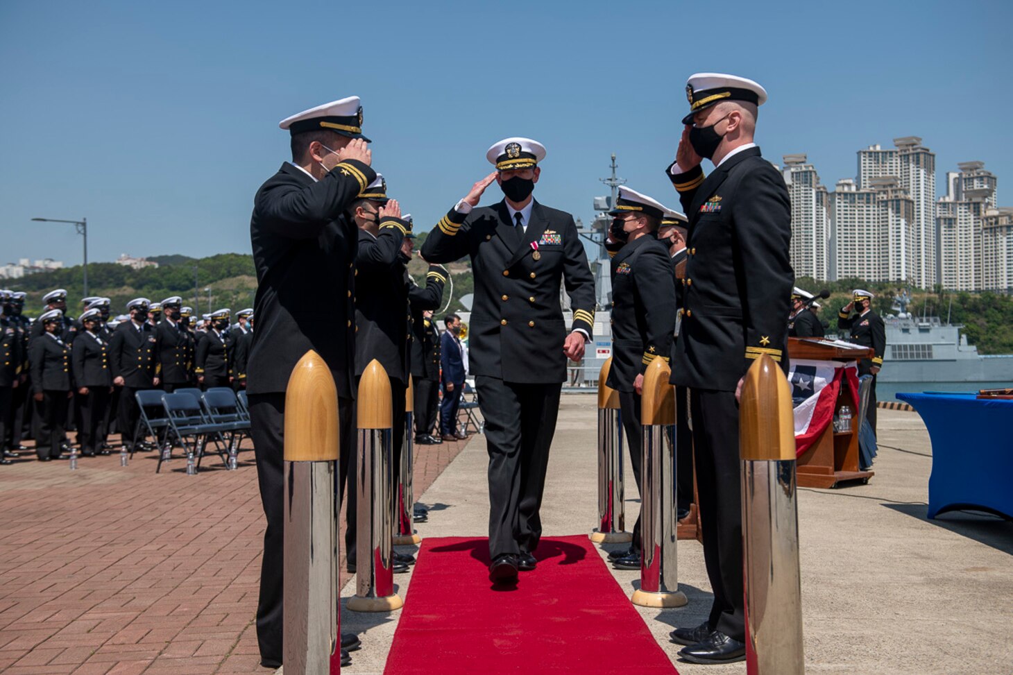 Commanding Officer Cmdr. Adam Soukup salutes side boys during the Change of Command ceremony for the Arleigh Burke-class guided-missile destroyer USS Sampson (DDG 102). Sampson is on a scheduled deployment in the U.S. 7th Fleet area of operations to enhance interoperability with alliances and partnerships while serving as a ready-response force in support of a free and open Indo-Pacific region.