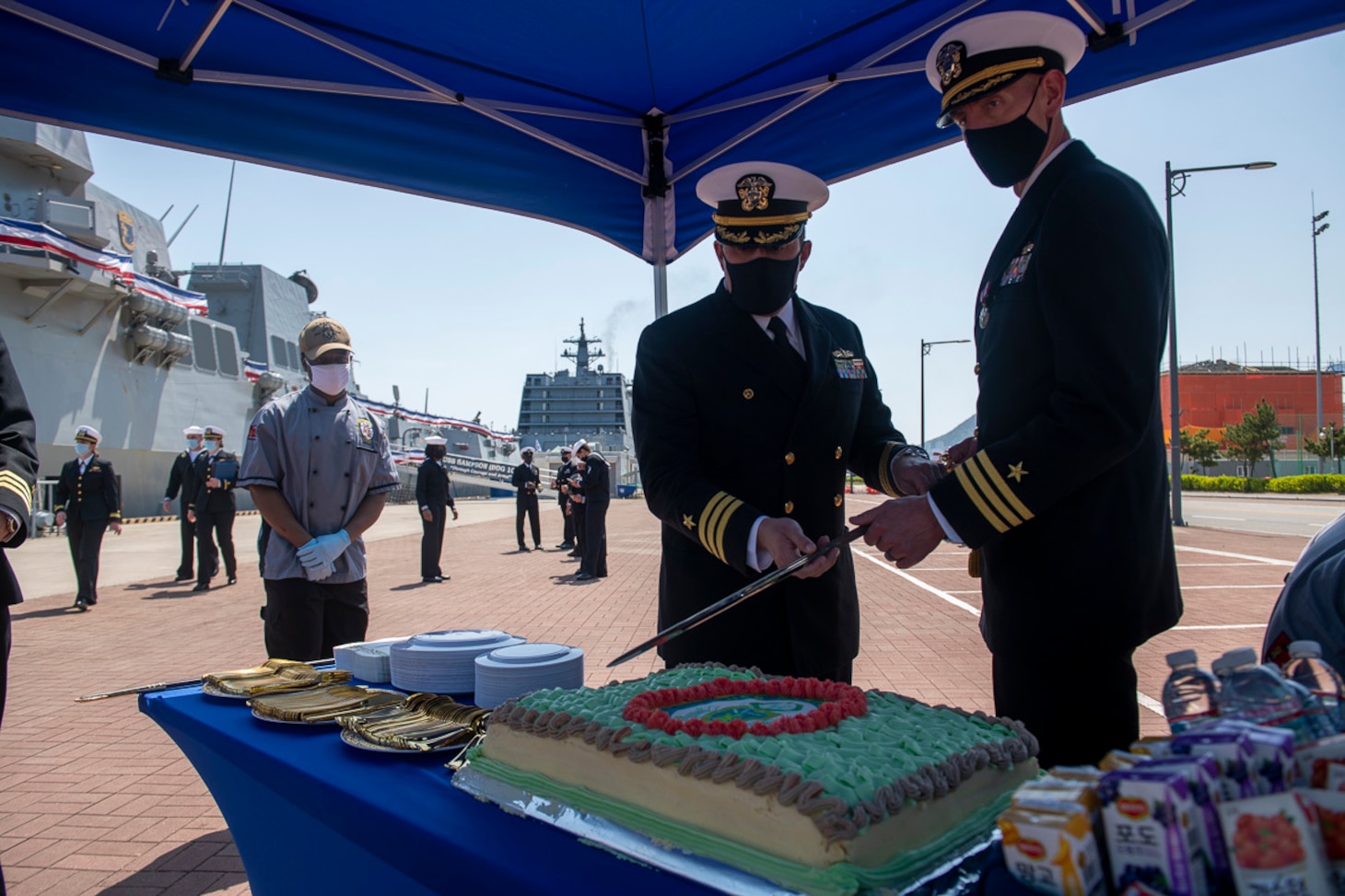Cmdr. William Bencini, Commanding Officer, and Cmdr. Adam Soukup cut the ceremonial cake during Change of Command for the Arleigh Burke-class guided-missile destroyer USS Sampson (DDG 102). Sampson is on a scheduled deployment in the U.S. 7th Fleet area of operations to enhance interoperability with alliances and partnerships while serving as a ready-response force in support of a free and open Indo-Pacific region.