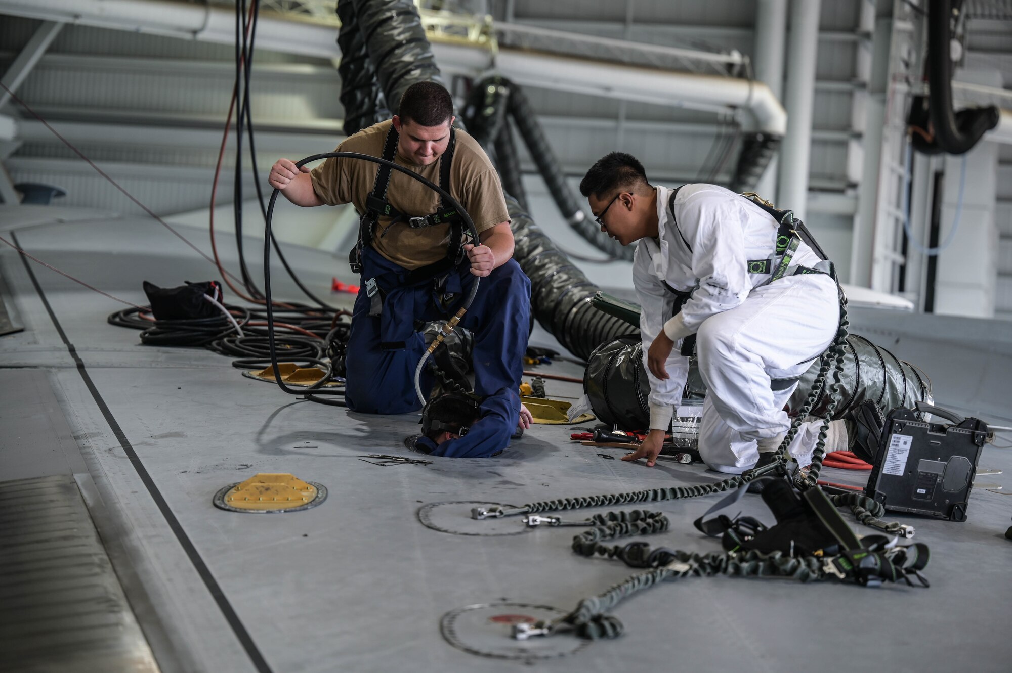 Maintainers assigned to the 154th Maintenance Squadron and 15th MXS begin an in-tank maintenance procedure on a C-17 Globemaster III at Joint Base Pearl Harbor-Hickam, Hawaii, May 2, 2022. The Airmen replaced an electrical wire harness, which provides electricity to the fuel pump for the number two engine. (U.S. Air Force photo by Staff Sgt. Alan Ricker)